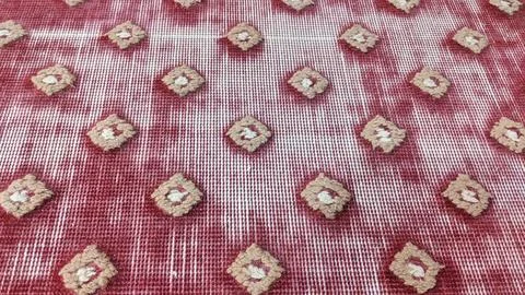 A red rug with a textured pattern of raised, light brown diamond shapes acr.. Stock Photos