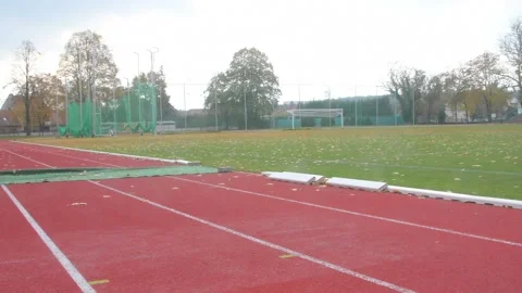 Red running track on athletic stadium in fall. Abandoned athletics track in 動画素材 164456626
