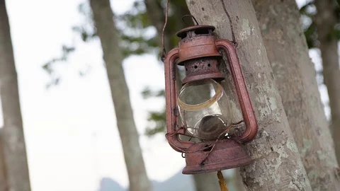 Red rusty old oil lantern wae broken hanging on tree Stock Footage 128675559