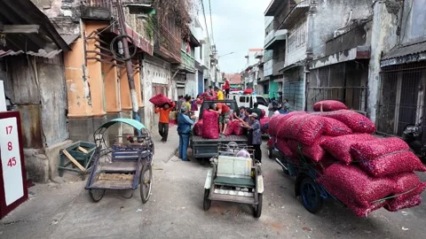Red sacks fill carts on narrow, sunlit streets Stock Footage 345145463