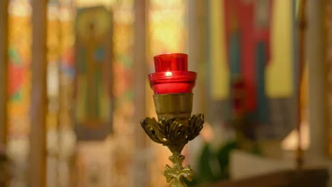 Red sanctuary candle burning inside a Christian church interior. Relig Stock Footage 327770974