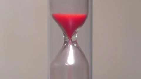 Red sand in hourglass. Time flows backwards, in the opposite direction Video stock 273518341