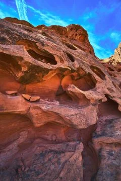 Red Sandstone Formations and Eroded Rock Cavities Against Blue Sky 写真素材