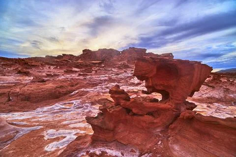 Red Sandstone Formations at Sunrise with Dramatic Clouds in Desert Landscape 스톡 사진