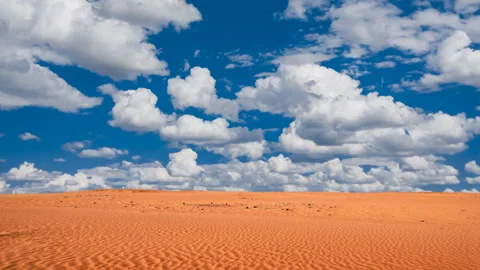 Red sandy desert under blue cloudy sky Vídeos de archivo 157300482