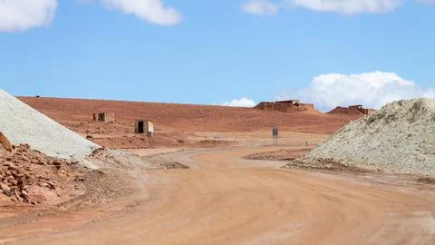 A red sandy track leads through the moon-like desert landscape of the Atacama Stock-Fotos