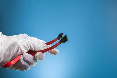 Red SATA interface cables in a hand on a blue background. Computer concept. Stock Photos