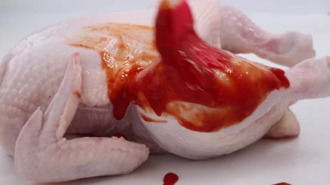 Red sauce is spread on fresh chicken to make baked chicken. Stock Footage 274464890