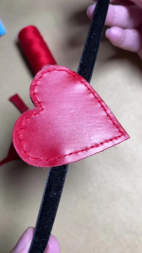 Red scarlet leather stitched heart spins on black rope. Occluder Stock Footage 262292453