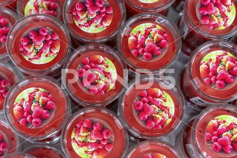 Red scented candles with raspberry flavor on the shop counter. Stock Photos