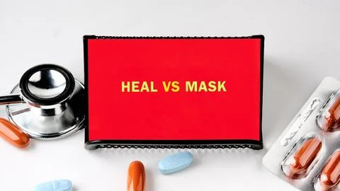 Red screen: Heal vs Mask text. Stethoscope, pills, blister pack. Visualizes f Stock Photos