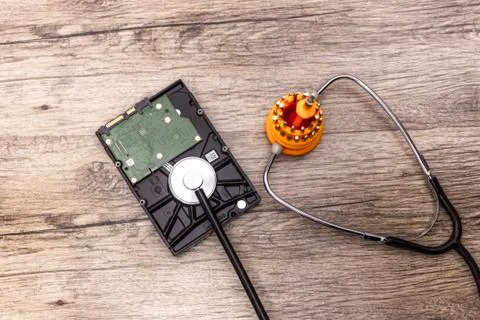 A red screwdriver cures a broken hard disk with stethoscope. Stock Photos