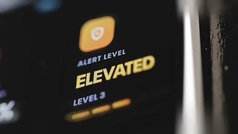 Red segmented warning dial displays Alert Level Elevated and Level 3 Stock Photos