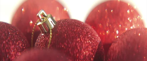 Red sequined baubles on white sliding 4K anamorphic video Stock Footage 316664930