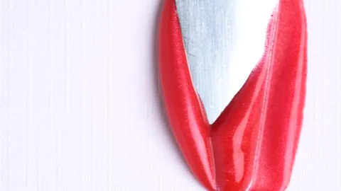 Red shiny gloss texture swatch on a white background. Metal spatula smears .. Vídeo Stock 271239716