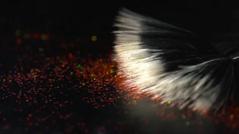 Red shiny sparkles falling on makeup brush on the black background, abstract Stock Footage 75964748