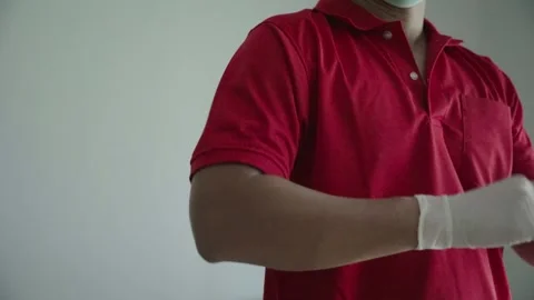 The red shirt delivery man is getting dressed and ready to go to work. Stock Footage 243662223