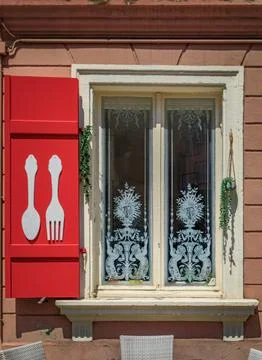 Red shutters with fork and spoon design on a restaurant window in Colmar, F.. Stock Photos