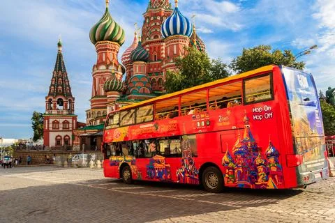 Red sightseeing double decker bus near St. Basil's Cathedral on Red square Stock Photos