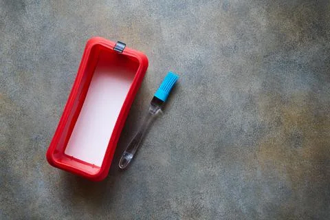 Red silicone form with ceramic bottom and silicone brush, baking kitchen uten Stock Photos