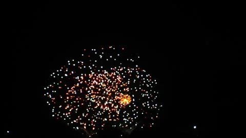 Red silver and blue bright sparks of fireworks on the black sky. General plan Stock Footage 308879969