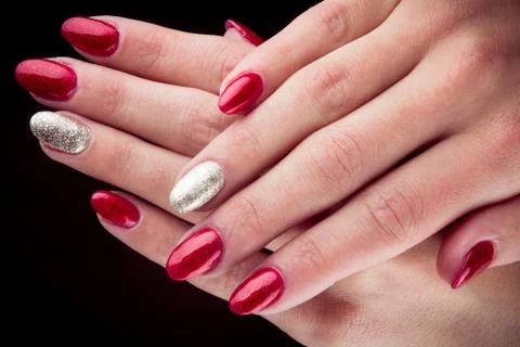 Red silver painted nails and hands isolated on black background Stock Photos