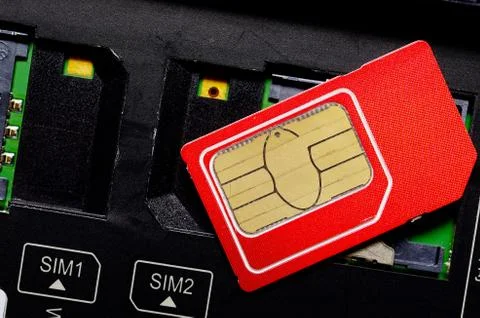 Red SIM card on slots in mobile phone. Stock Photos