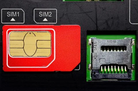 Red SIM card on slots in mobile phone. Stock Photos