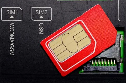 Red SIM card on slots in mobile phone. Stock Photos