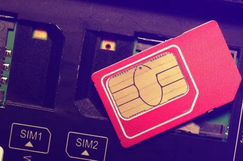 Red SIM card on slots in mobile phone. Stock Photos