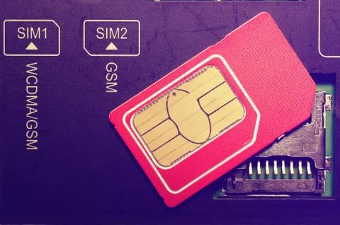 Red SIM card on slots in mobile phone. Stock Photos