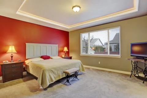 Red simple bedroom with big bed and large window. Stock Photos