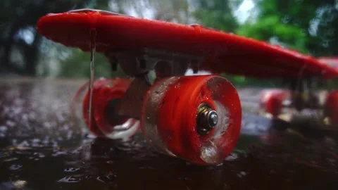 Red skateboard in the rain Stock Footage 154428297