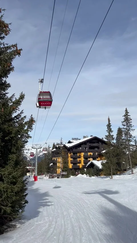 Red ski lifts in front of Cheval Blanc hotel slope, in Courchevel ski resort Stock Footage 337244241
