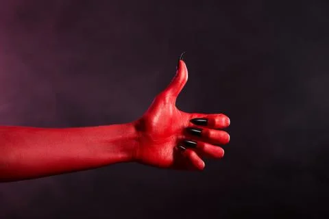 Red skin devil hand showing thumbs up Foto stock