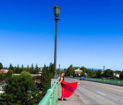 Red Skirted Dancer doing an arabesque by lightpole Stock Photos