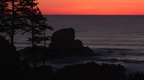 Red sky at dusk with large rocks in surf line Stock Footage 60407686