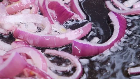 Red sliced ??onion is fried in vegetable oil hot frying pan. Medium shot. Stock Footage 302917936