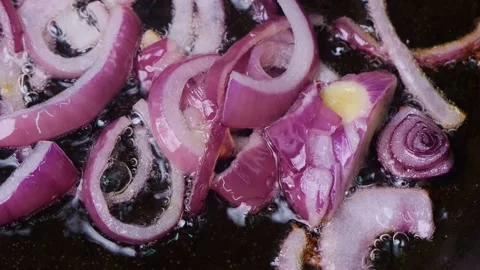 Red sliced ??onion is fried in vegetable oil hot frying pan. Medium shot. Stock Footage 310207273