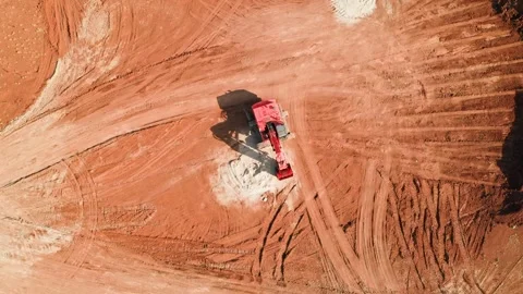 Red small excavator standing in on red clay ground 스톡 동영상 255805750