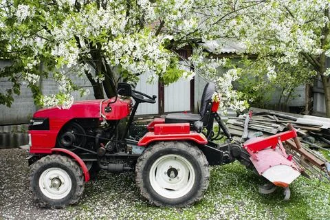 Red small modern mini tractor standing at the farm Stock Photos