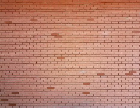 Red smooth brick wall texture with dark colored bricks Фото