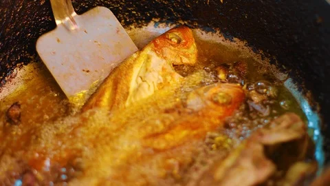 Red snapper fish being fried in oil in deep pan Stock Footage 119552771