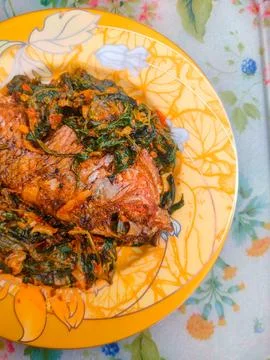 Red Snapper Fish cooked with spicy sambal, and Green Onions, Tomatos and Ba.. Stock Photos