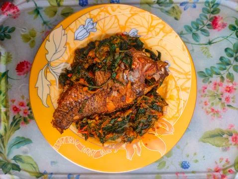 Red Snapper Fish cooked with spicy sambal, and Green Onions, Tomatos and Ba.. Stock Photos