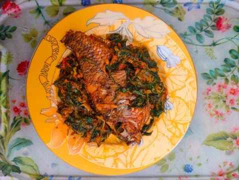 Red Snapper Fish cooked with spicy sambal, and Green Onions, Tomatos and Ba.. Stock Photos