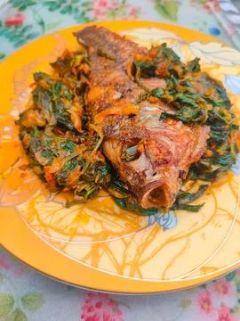 Red Snapper Fish cooked with spicy sambal, and Green Onions, Tomatos and Ba.. Stock Photos