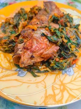 Red Snapper Fish cooked with spicy sambal, and Green Onions, Tomatos and Ba.. Stock Photos