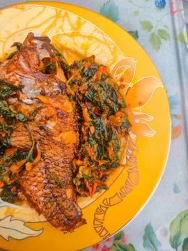 Red Snapper Fish cooked with spicy sambal, and Green Onions, Tomatos and Ba.. Stock Photos