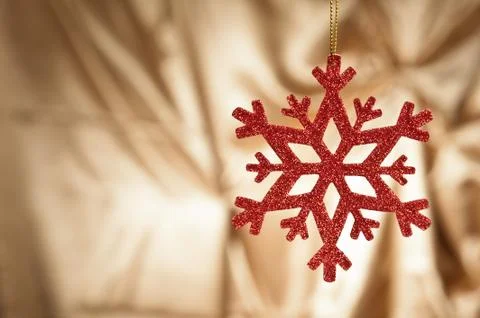 Red snow flake on a gold background 스톡 사진